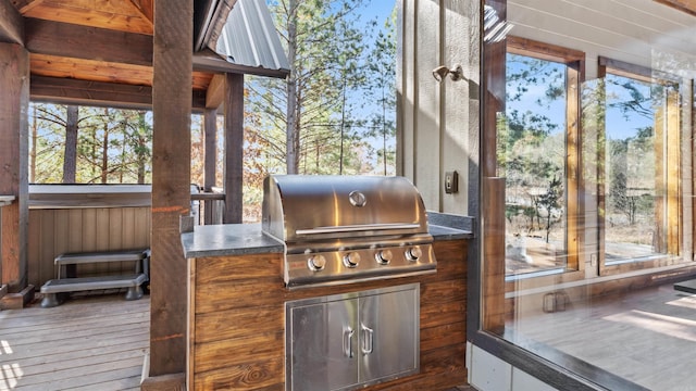 wooden deck featuring grilling area and an outdoor kitchen