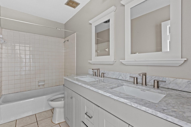 full bathroom featuring tile patterned flooring, tiled shower / bath combo, toilet, and vanity