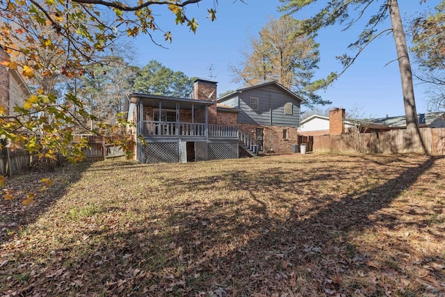 rear view of house with a sunroom and a lawn