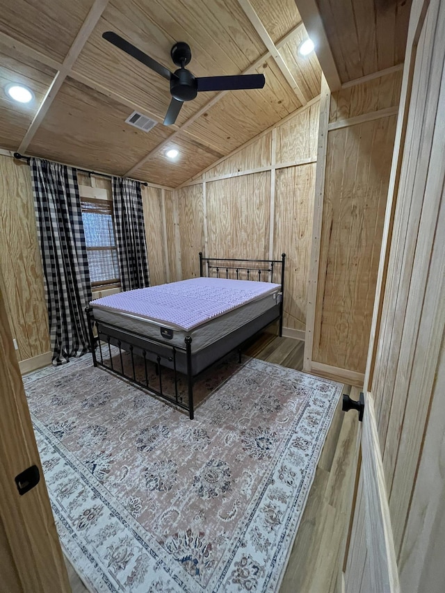 bedroom featuring hardwood / wood-style flooring, ceiling fan, wooden ceiling, and wood walls