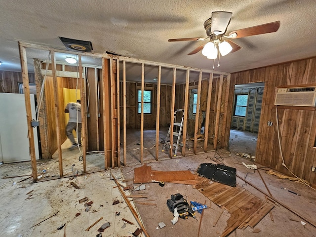 miscellaneous room featuring an AC wall unit, ceiling fan, and a textured ceiling