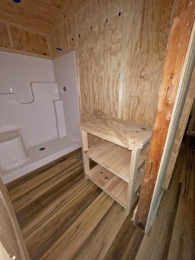 bathroom with hardwood / wood-style flooring and wooden walls