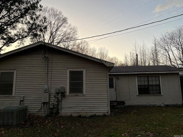 back house at dusk with central air condition unit