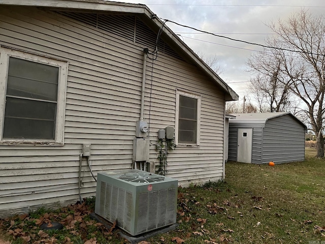 view of property exterior featuring a yard, cooling unit, and a shed