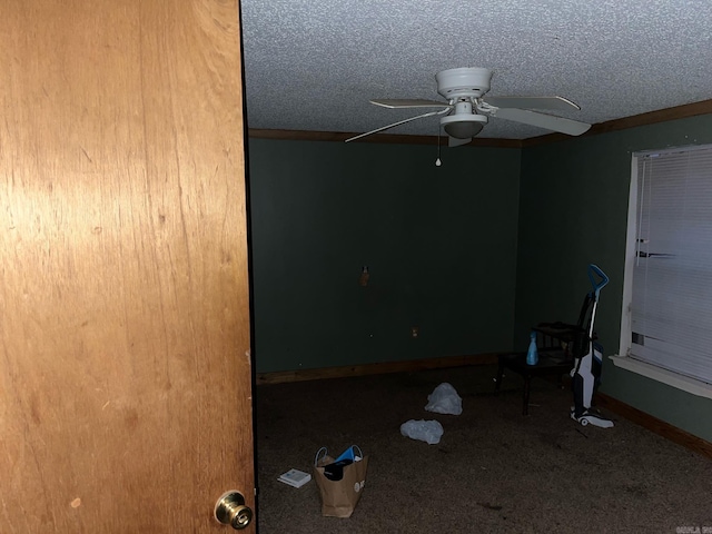 empty room with carpet flooring, ceiling fan, and a textured ceiling