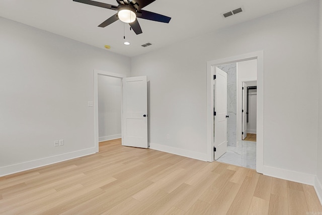 unfurnished bedroom featuring connected bathroom, ceiling fan, and light hardwood / wood-style floors