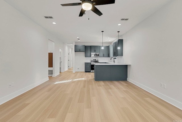 kitchen with sink, kitchen peninsula, pendant lighting, light hardwood / wood-style floors, and appliances with stainless steel finishes