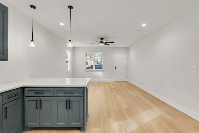 kitchen with light wood-type flooring, decorative light fixtures, ceiling fan, and gray cabinetry