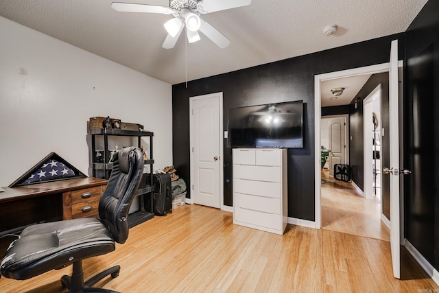 office area featuring a textured ceiling, light hardwood / wood-style floors, and ceiling fan