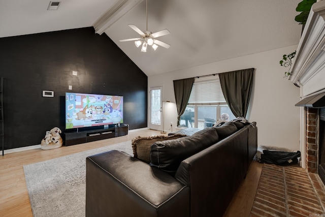 living room featuring hardwood / wood-style flooring, lofted ceiling with beams, ceiling fan, and a brick fireplace