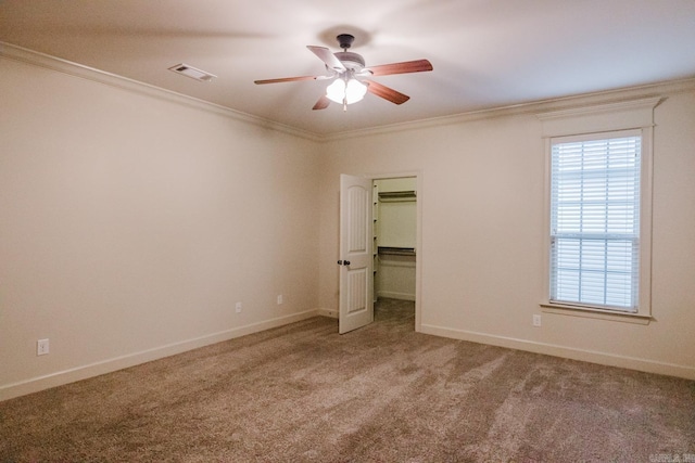 unfurnished bedroom featuring ceiling fan, crown molding, and carpet floors