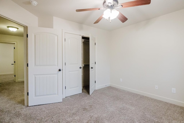 unfurnished bedroom featuring ceiling fan, a closet, and light colored carpet