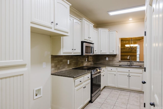 kitchen featuring sink, dark stone countertops, decorative backsplash, white cabinets, and appliances with stainless steel finishes