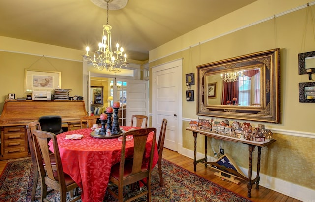 dining area featuring wood-type flooring and a notable chandelier