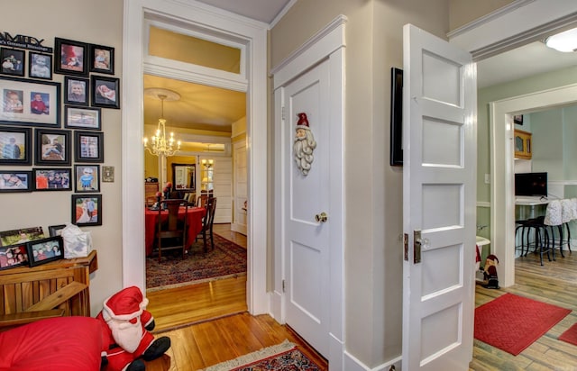 corridor with an inviting chandelier and hardwood / wood-style flooring