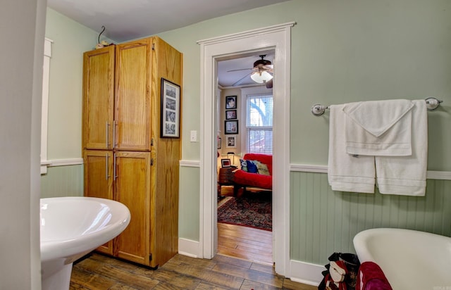 bathroom featuring a bath, hardwood / wood-style floors, ceiling fan, and ornamental molding