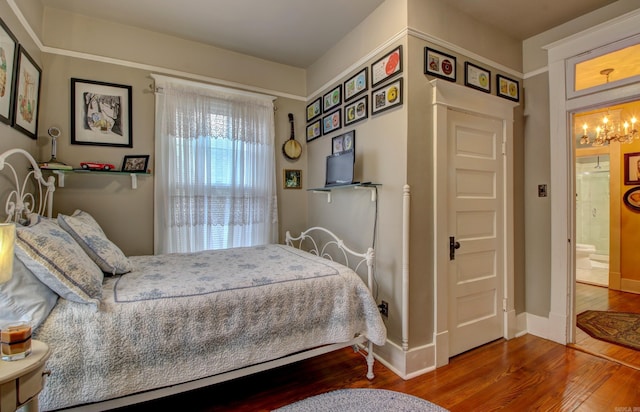 bedroom featuring wood-type flooring and a notable chandelier