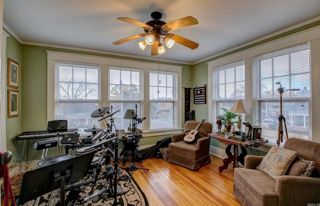 home office with a healthy amount of sunlight, crown molding, ceiling fan, and light hardwood / wood-style floors