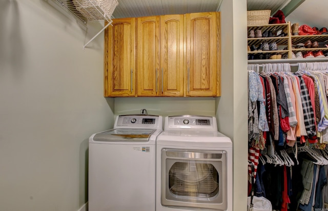 clothes washing area with washer and dryer and cabinets