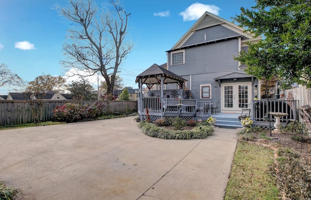 back of house with a gazebo, a wooden deck, and french doors