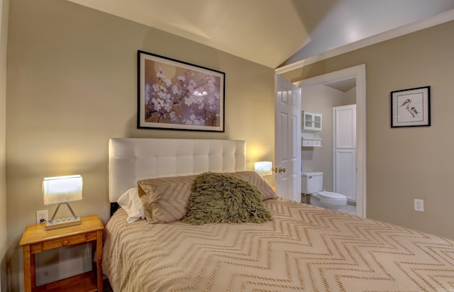 bedroom with ensuite bathroom and vaulted ceiling