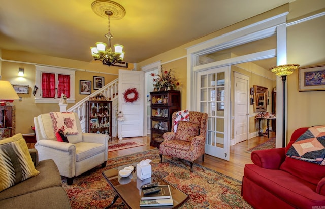 living room with light hardwood / wood-style floors and an inviting chandelier