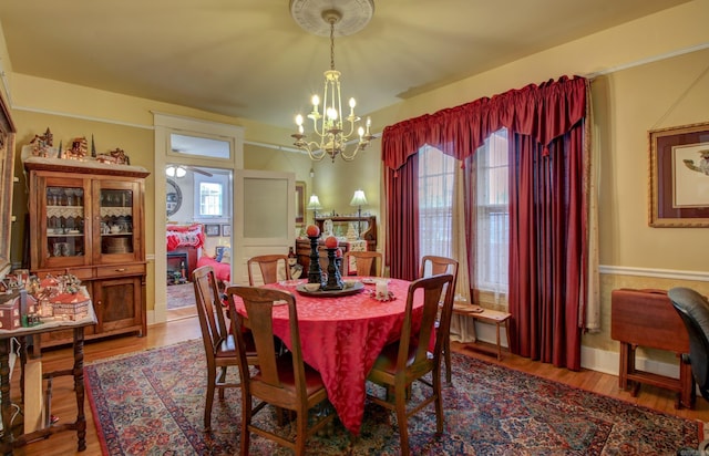 dining area with hardwood / wood-style floors and a chandelier