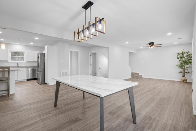 interior space with ceiling fan, sink, and light hardwood / wood-style floors