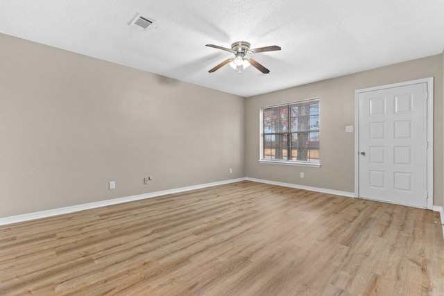 spare room with ceiling fan, a textured ceiling, and light wood-type flooring