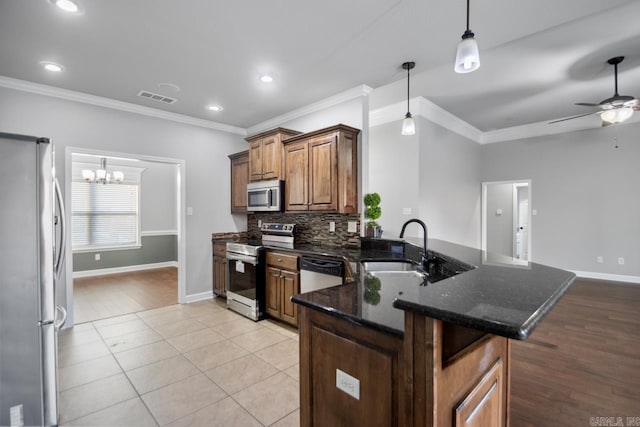 kitchen featuring ceiling fan with notable chandelier, sink, ornamental molding, light tile patterned floors, and stainless steel appliances