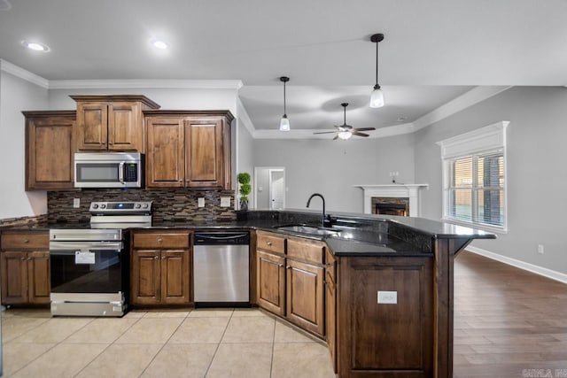 kitchen featuring sink, ceiling fan, ornamental molding, light tile patterned flooring, and stainless steel appliances