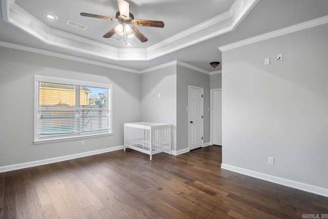 spare room with a raised ceiling, dark hardwood / wood-style flooring, and ornamental molding