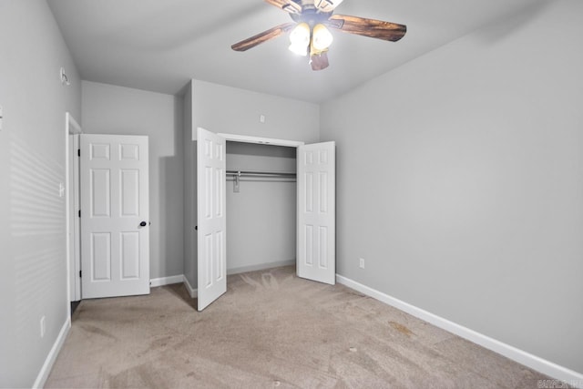 unfurnished bedroom featuring ceiling fan, a closet, and light carpet