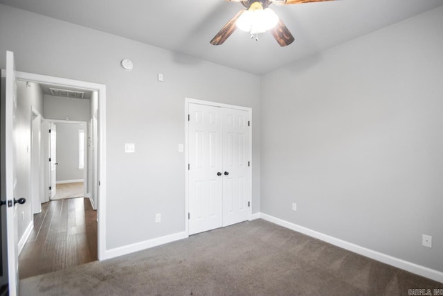 unfurnished bedroom with ceiling fan, dark hardwood / wood-style floors, and a closet