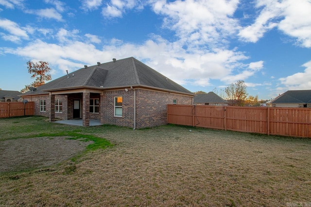 back of house with a lawn and a patio area