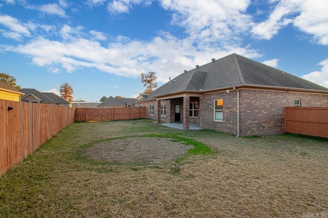 back of property with a yard and a patio