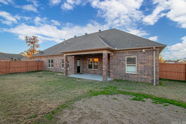 rear view of house featuring a yard and a patio