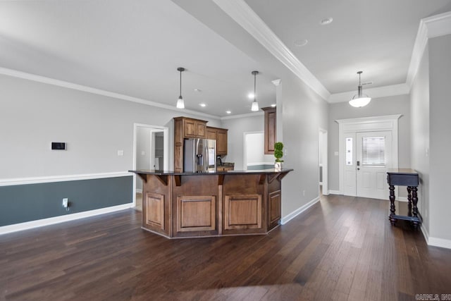 kitchen featuring stainless steel fridge, a kitchen breakfast bar, crown molding, dark wood-type flooring, and hanging light fixtures