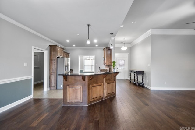 kitchen with pendant lighting, crown molding, dark wood-type flooring, and stainless steel refrigerator with ice dispenser