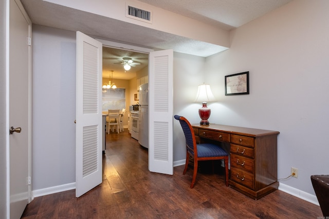 office area with ceiling fan with notable chandelier, dark hardwood / wood-style flooring, and a textured ceiling