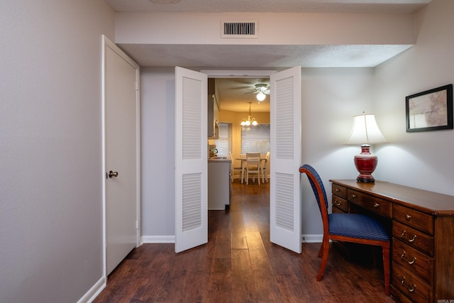 office area featuring ceiling fan with notable chandelier, a textured ceiling, and dark hardwood / wood-style flooring