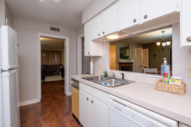 kitchen with sink, dark hardwood / wood-style flooring, decorative light fixtures, white appliances, and white cabinets