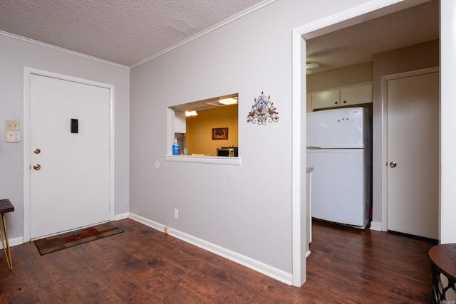 foyer entrance with a textured ceiling, crown molding, and dark wood-type flooring