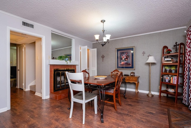 dining area featuring a tiled fireplace, dark hardwood / wood-style flooring, a chandelier, and ornamental molding