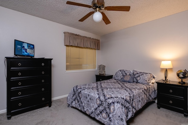 carpeted bedroom with ceiling fan and a textured ceiling