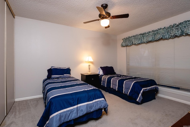 bedroom featuring carpet flooring, ceiling fan, a closet, and a textured ceiling