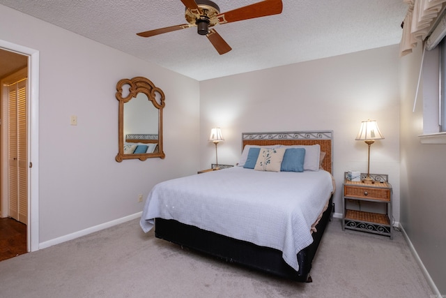 carpeted bedroom with a textured ceiling, a closet, and ceiling fan