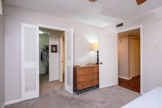 carpeted bedroom featuring a textured ceiling, a closet, and ceiling fan