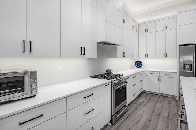 kitchen with decorative backsplash, light wood-type flooring, white cabinetry, and appliances with stainless steel finishes