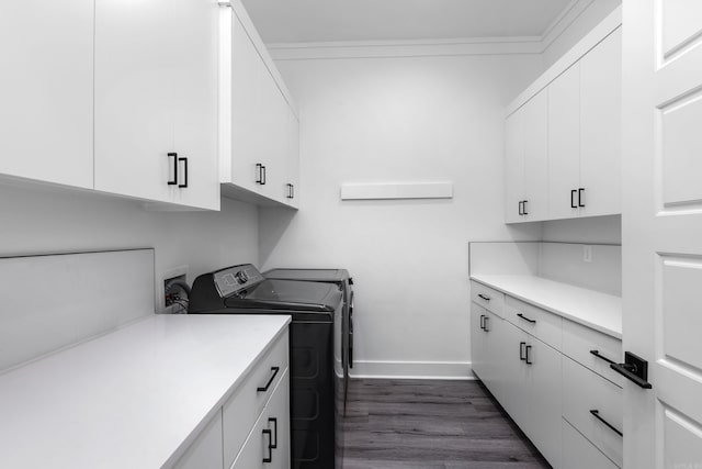 clothes washing area featuring separate washer and dryer, crown molding, cabinets, and dark hardwood / wood-style floors